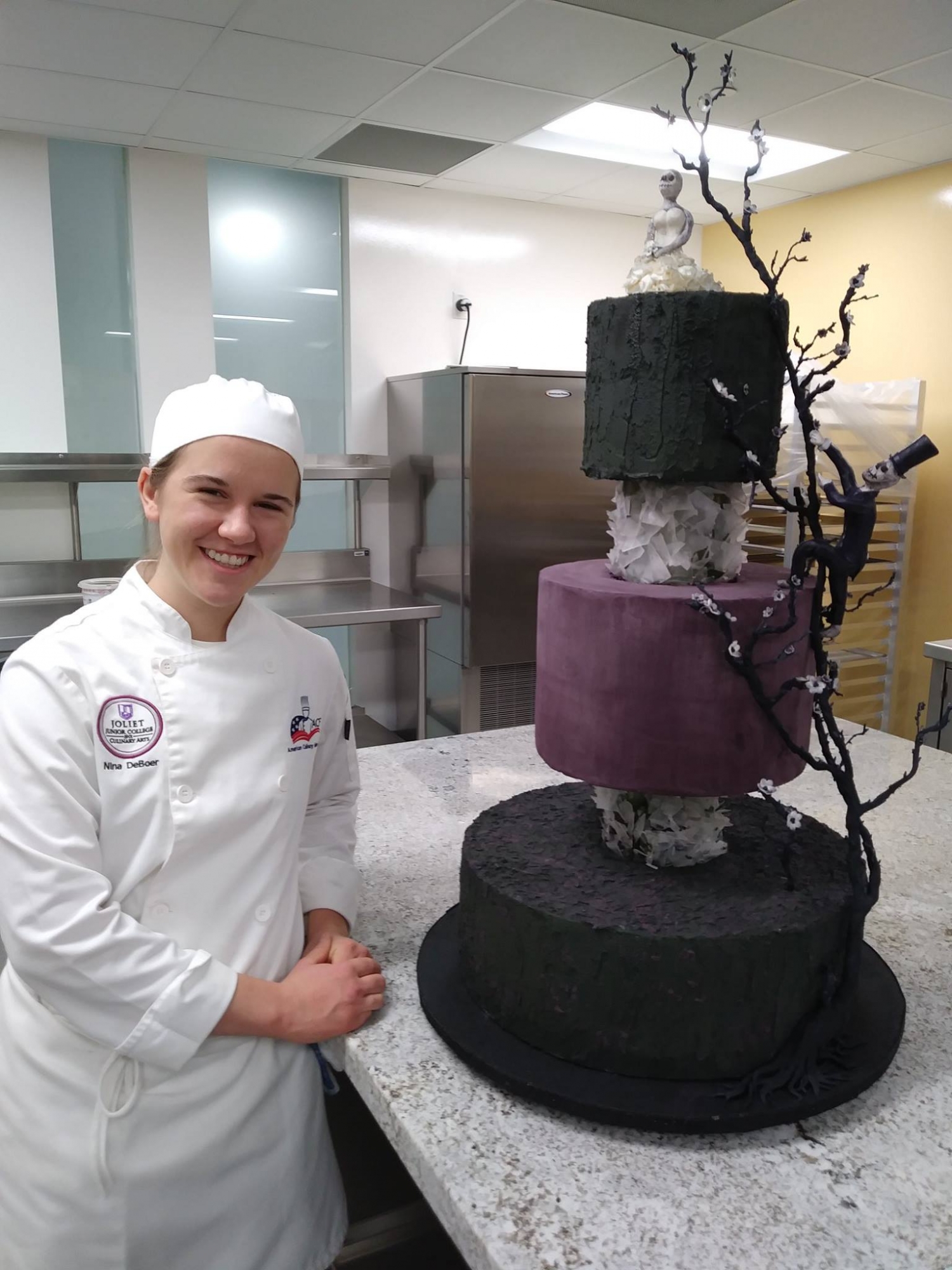 Nina DeBoer posing next to her award-winning cake